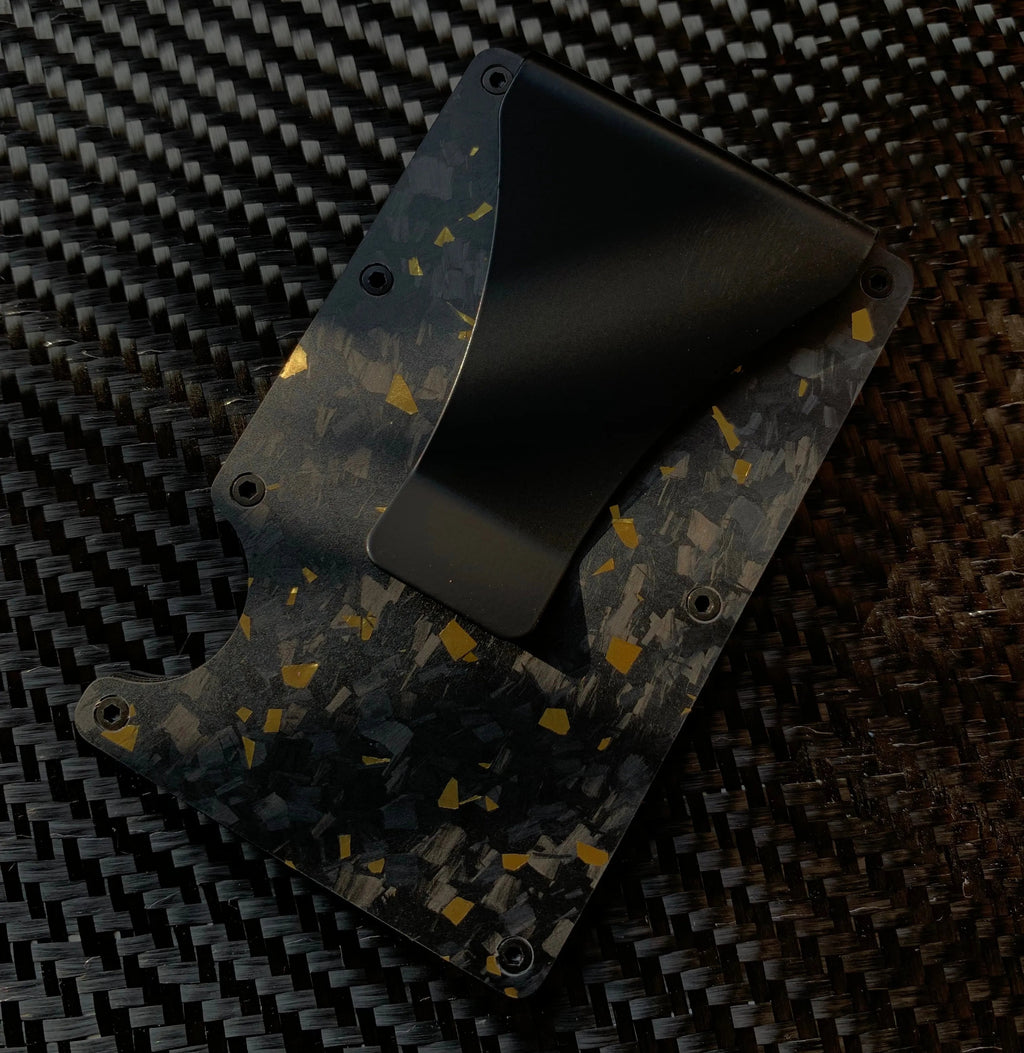 Black and gold patterned wallet on a carbon fiber background